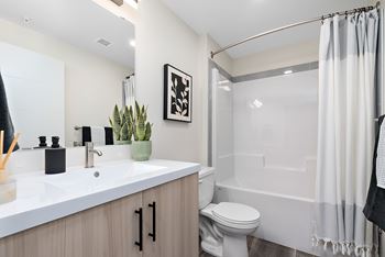A bathroom with a white sink, toilet, and bathtub.